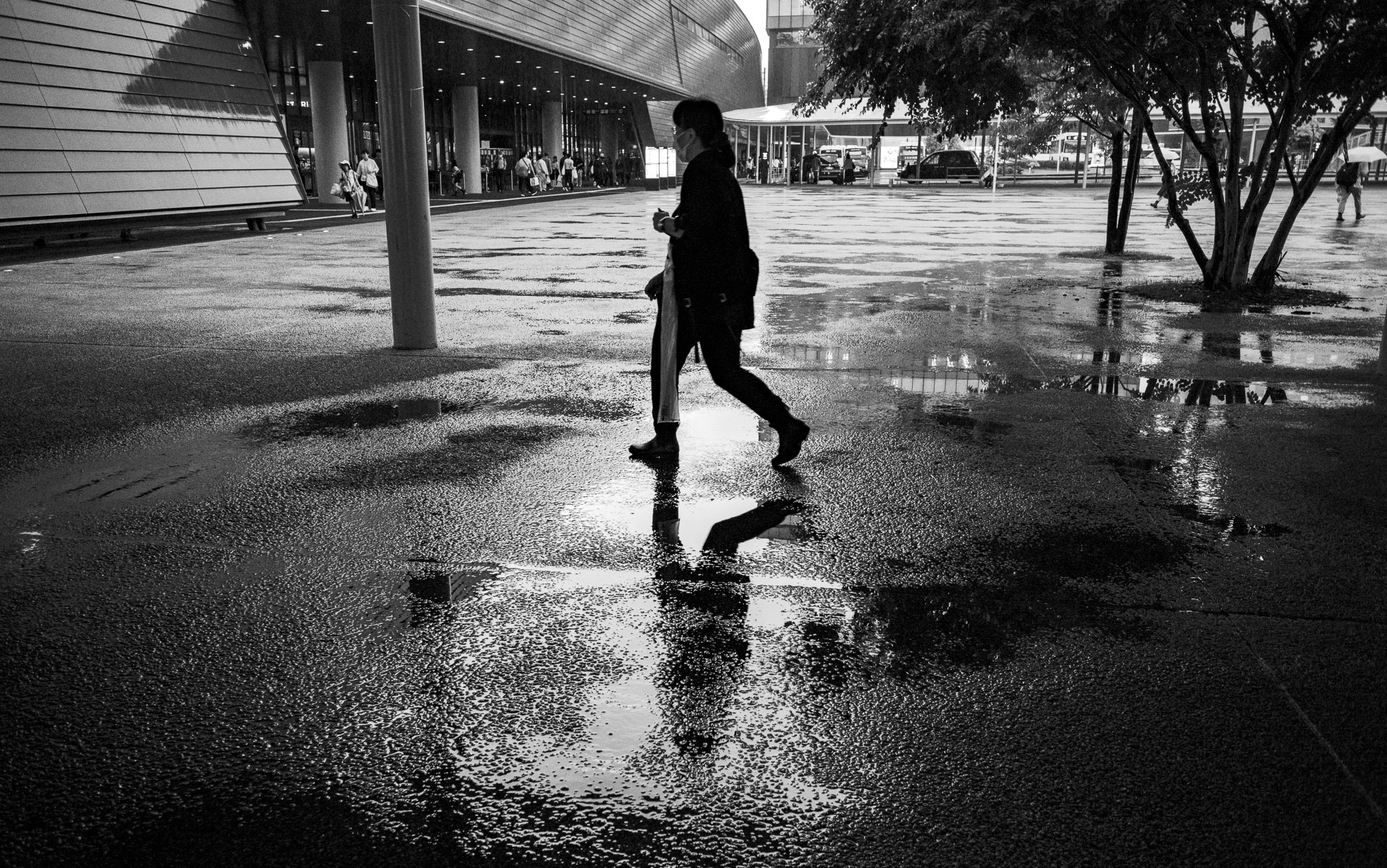 The plaza doubles her — once in the world, once in the water.