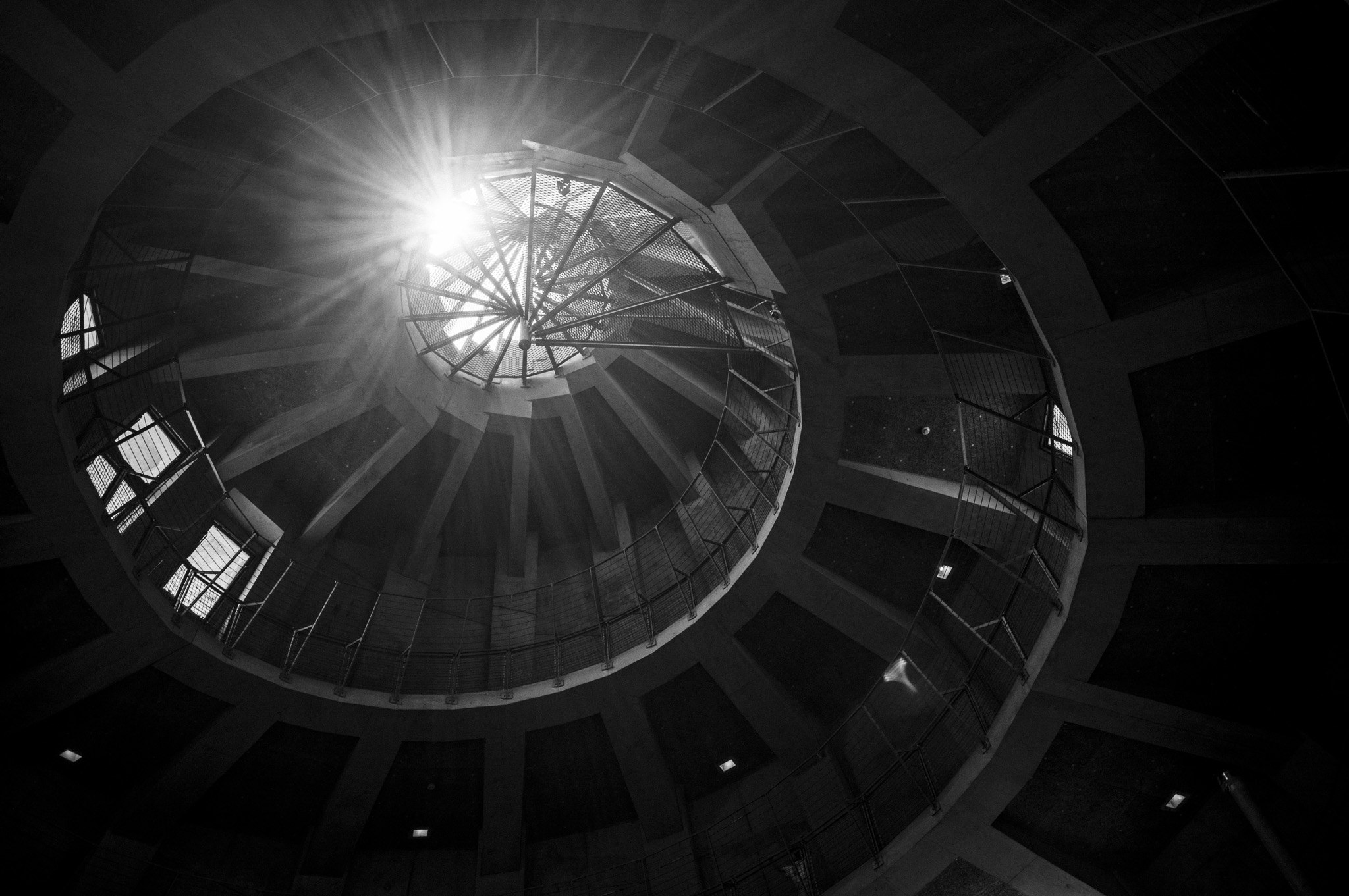 A staircase spirals toward one point of light — call it an iris, if you like.