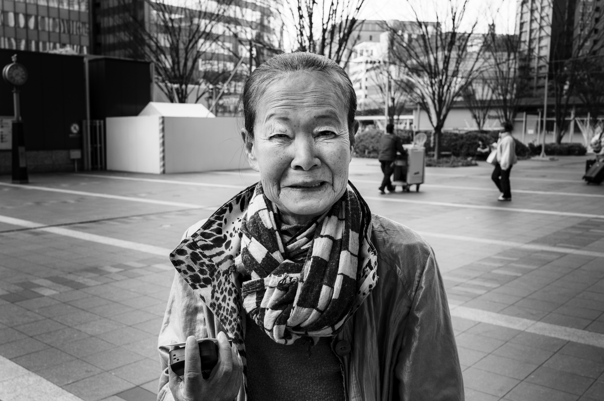 The plaza empties around her, but her face holds every year it has seen.