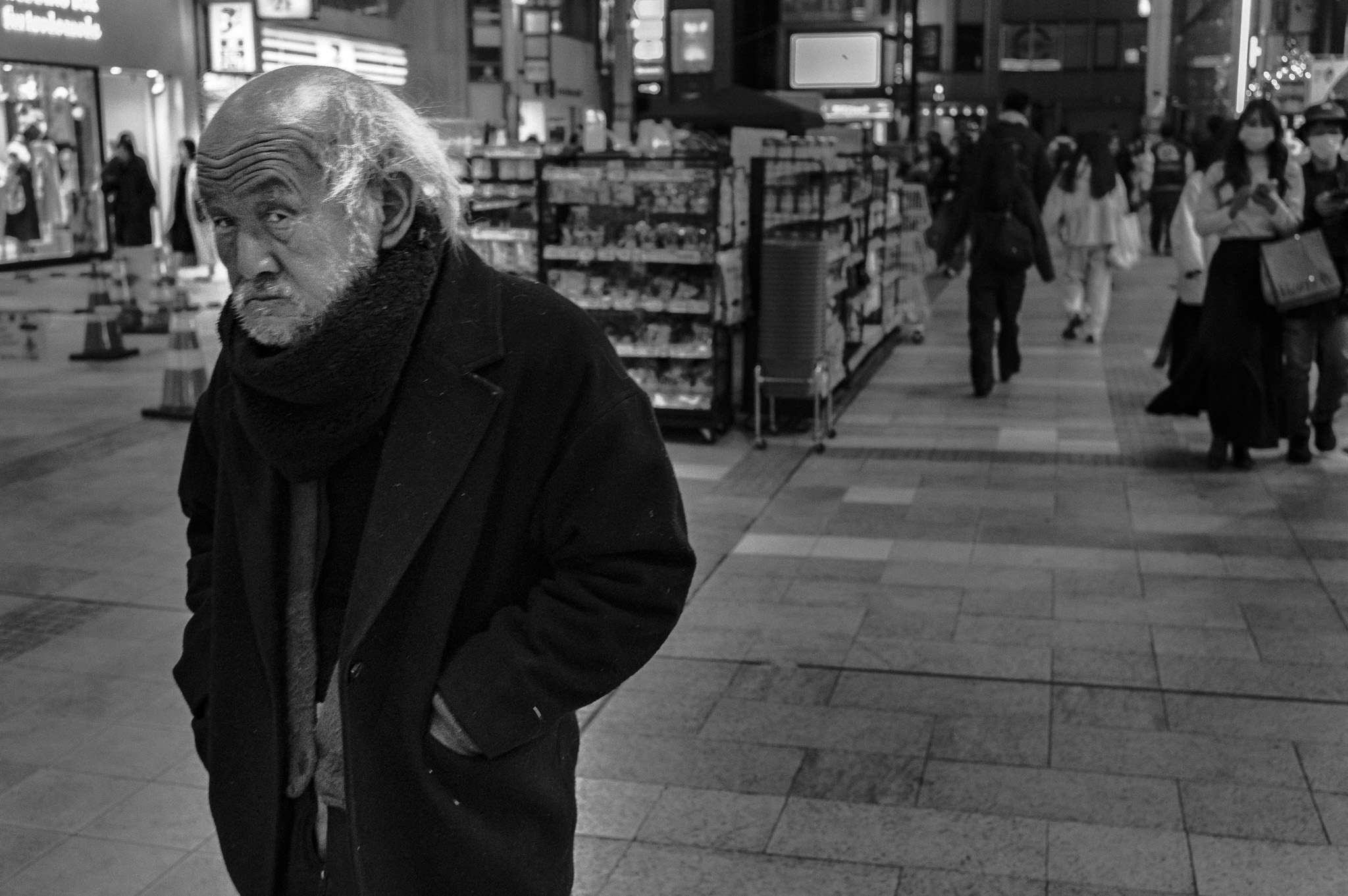 Everyone else in the frame keeps walking. He is the one who turns to ask why he's being looked at.
